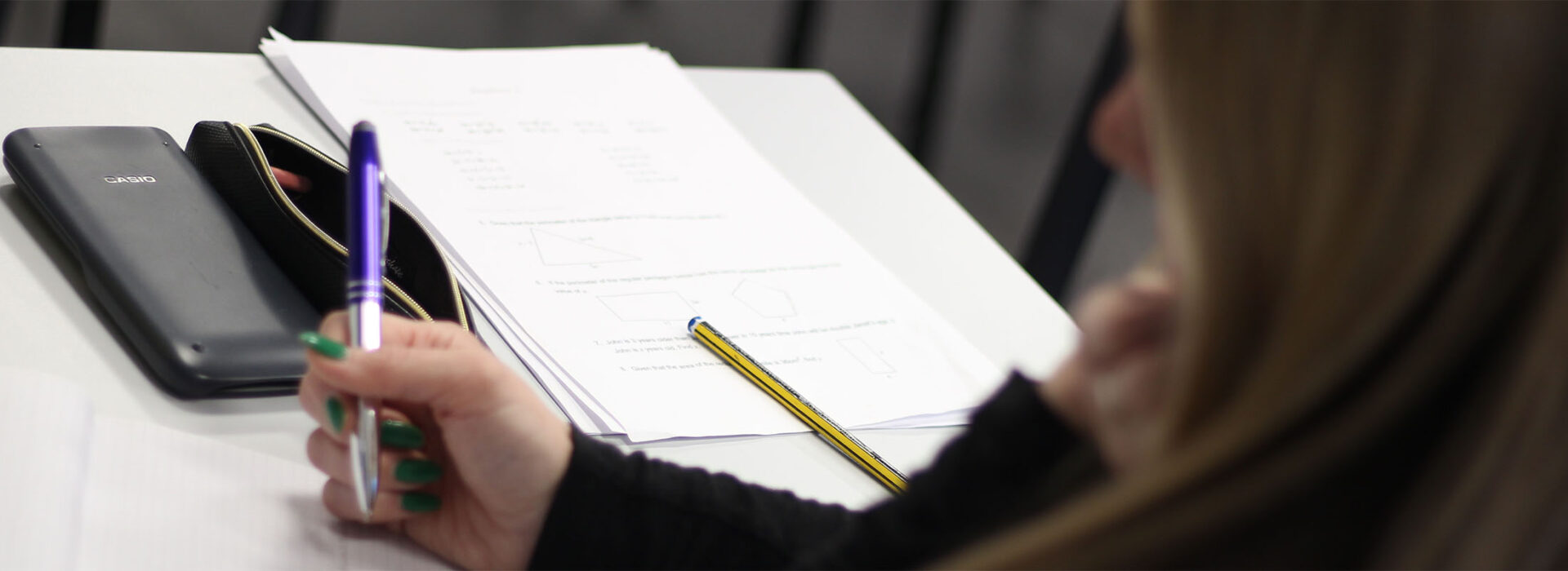 Cropped photograph of a student studying with a calculator